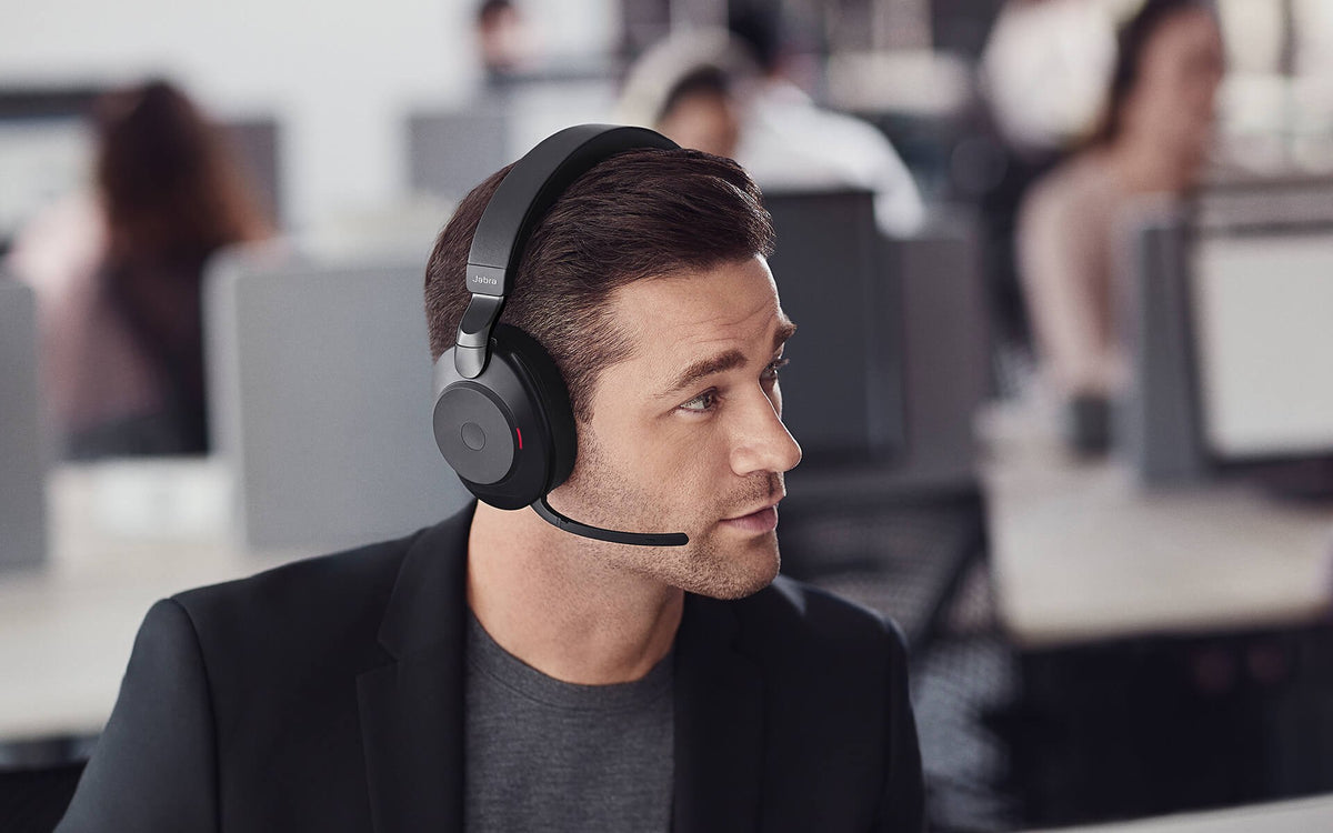 Man wearing a Jabra Evolve2 85 noise-cancelling headset in an open-plan office
