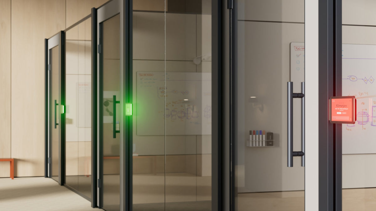 Logitech Tap Scheduler panels with green and red availability lights outside glass meeting rooms