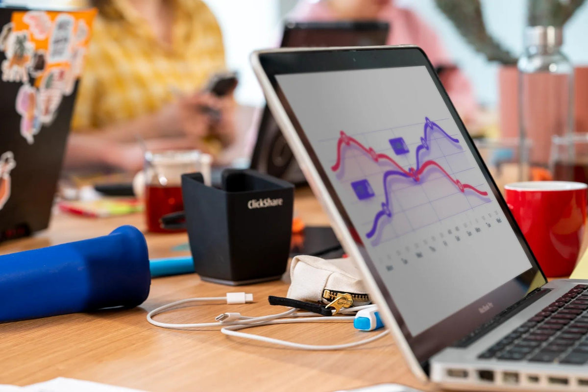 Barco ClickShare base unit and a laptop on a small meeting room table