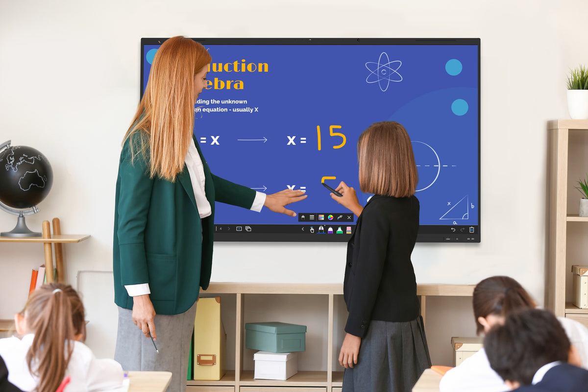 Teacher and pupil writing on a Clevertouch IMPACT Lux 2 display in a classroom