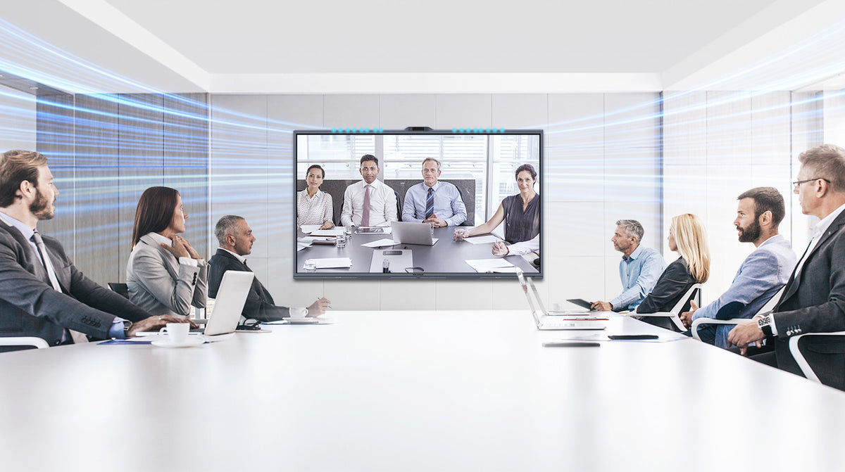 Boardroom video call on a MAXHUB XBoard V7 display at the end of a long table