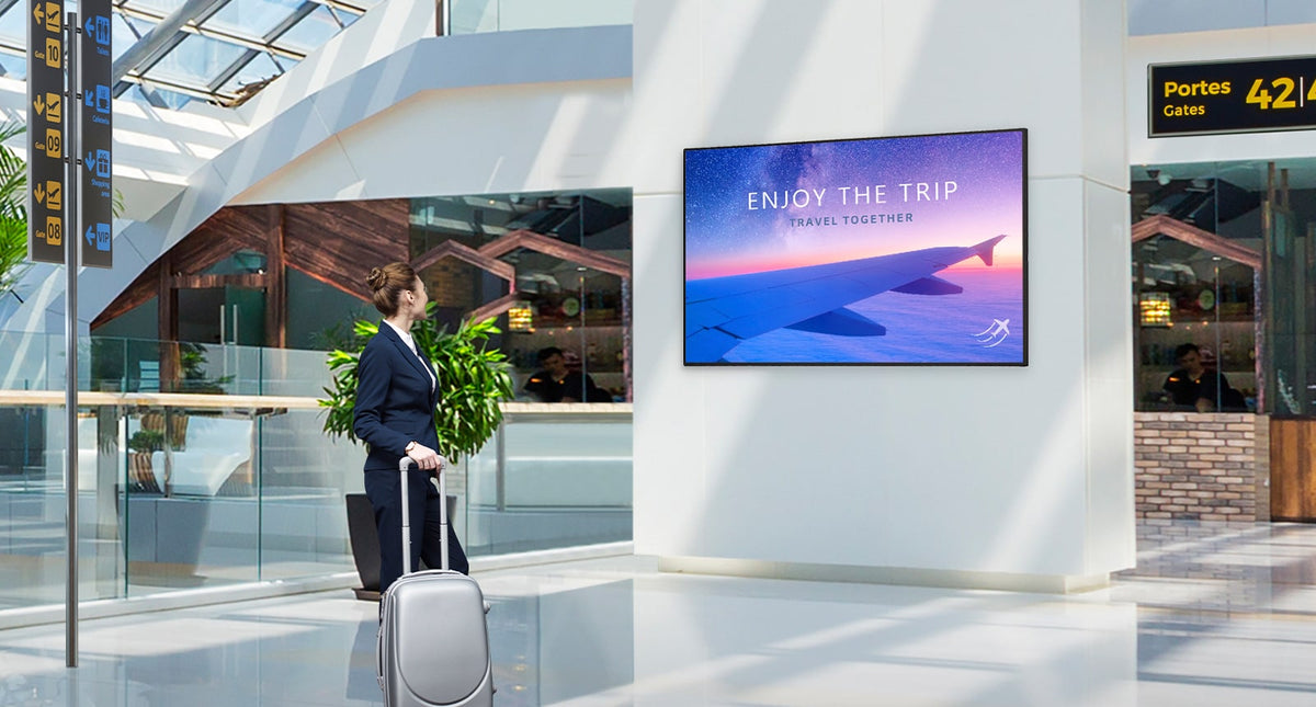 LG UH7N-E UHD signage display on a wall in an airport terminal