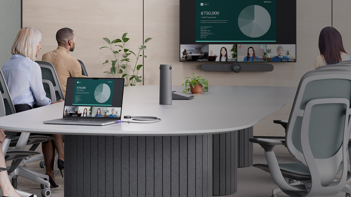 Meeting room with a laptop connected at the table and a Logitech video bar below the display