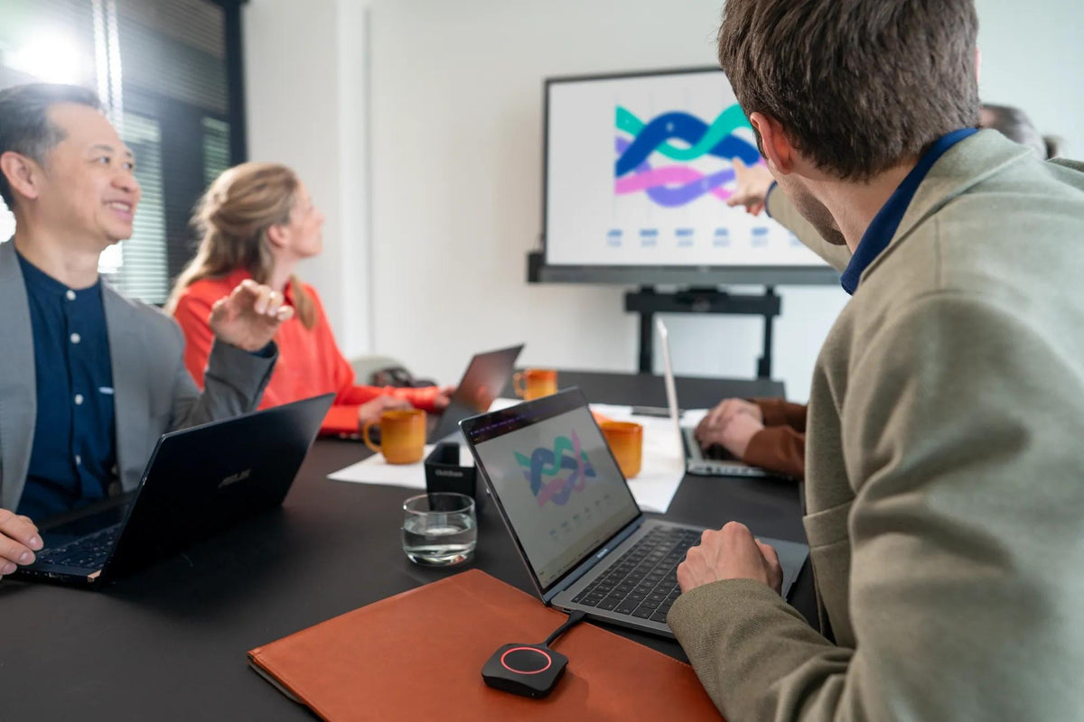 Presenter sharing a laptop to the meeting room display with a Barco ClickShare Button