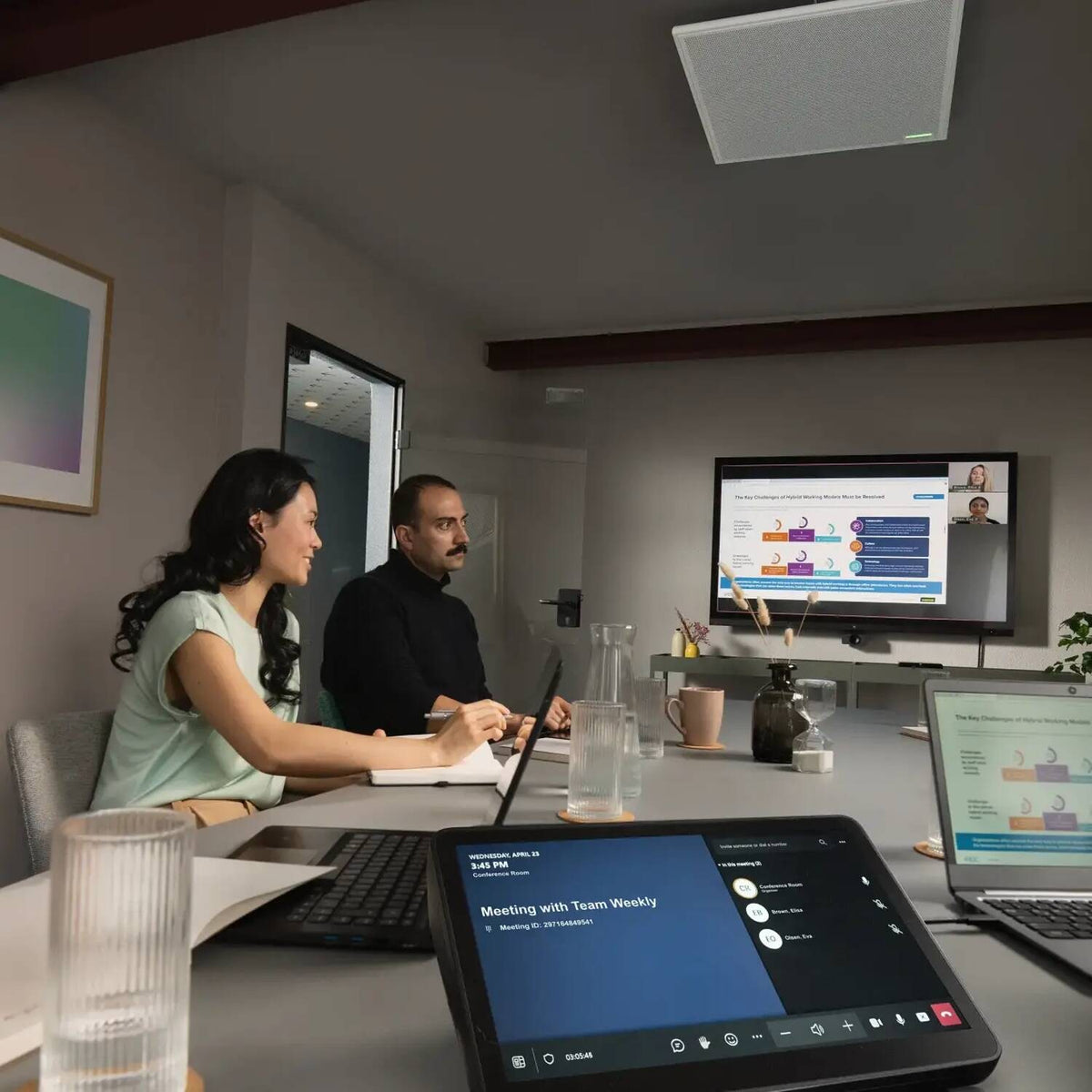 Shure MXA902 ceiling array microphone above a meeting table with a touch panel